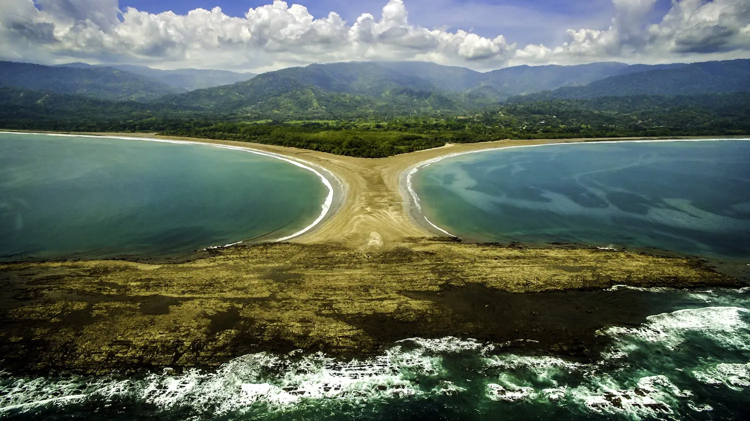 The Whale's Tail sandbar at Marino Ballena National Park from the air, with the Fila Costeña mountains behind