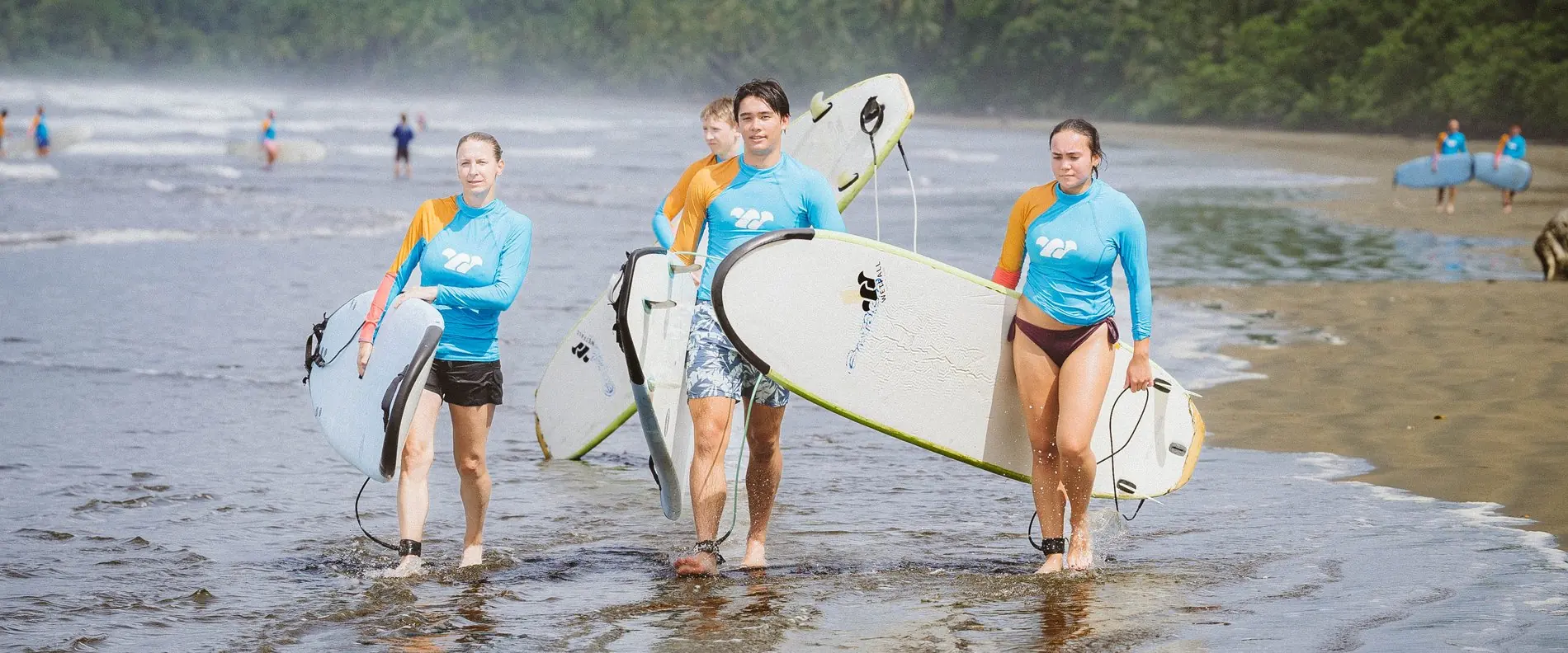 Surf class heading into the water with their boards